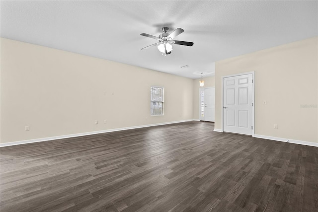 spare room with dark wood-style floors, ceiling fan, baseboards, and a textured ceiling