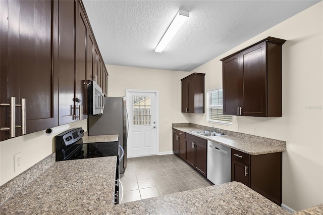 kitchen featuring dark brown cabinetry, a wealth of natural light, stainless steel appliances, and a sink