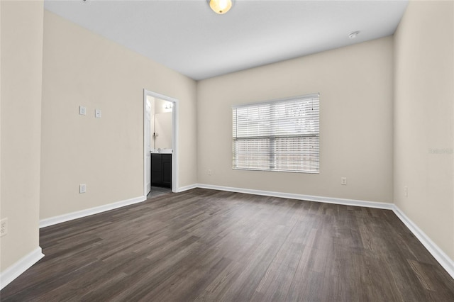 spare room with dark wood-style floors and baseboards