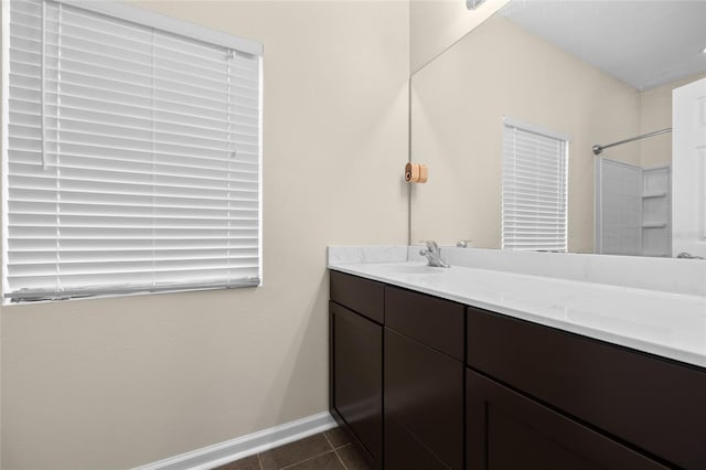 bathroom with vanity, baseboards, and tile patterned floors