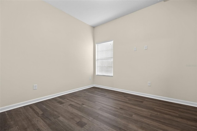 unfurnished room featuring baseboards and dark wood finished floors