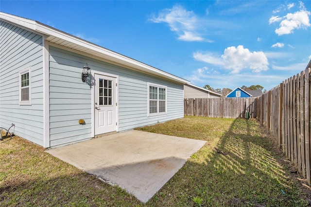 rear view of property featuring a patio area, a fenced backyard, and a yard