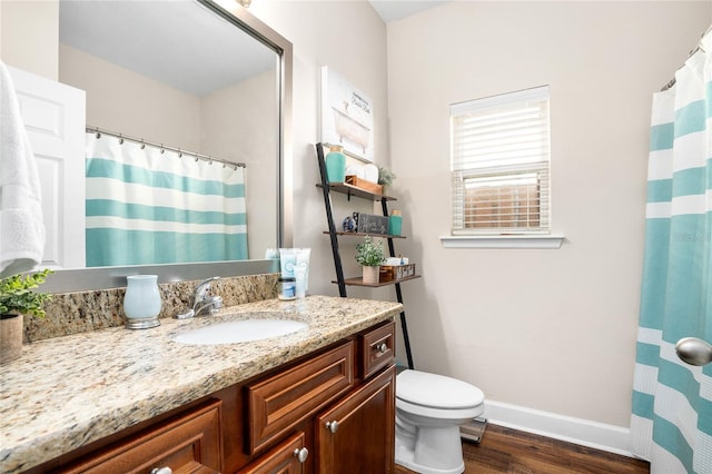 full bath with baseboards, a shower with shower curtain, toilet, wood finished floors, and vanity