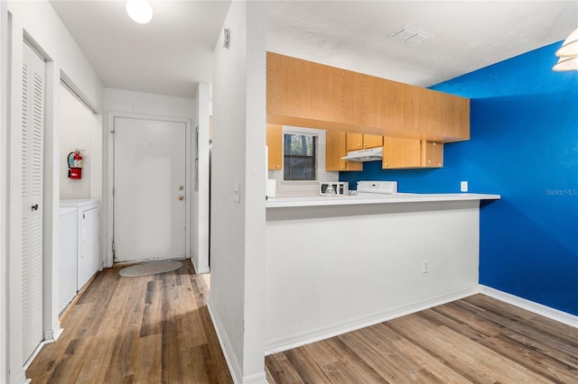 kitchen with baseboards, separate washer and dryer, wood finished floors, and under cabinet range hood