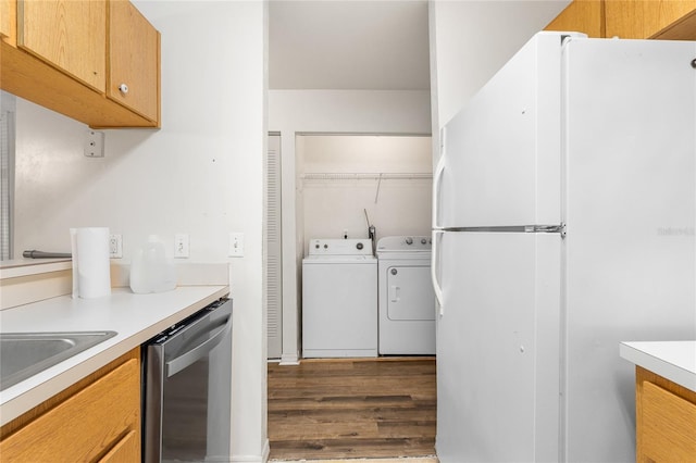 kitchen featuring dark wood-style floors, washing machine and clothes dryer, light countertops, stainless steel dishwasher, and freestanding refrigerator