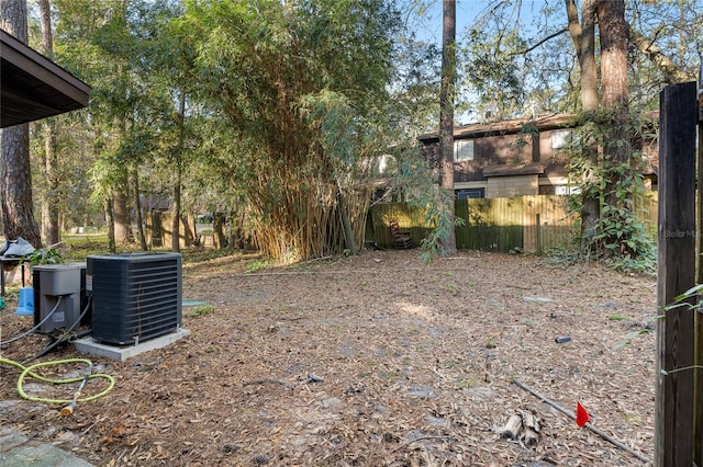 view of yard featuring fence and central air condition unit