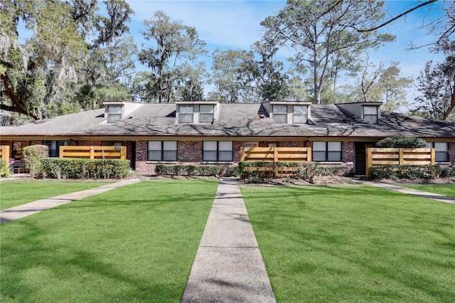 view of front of home with a front lawn and brick siding