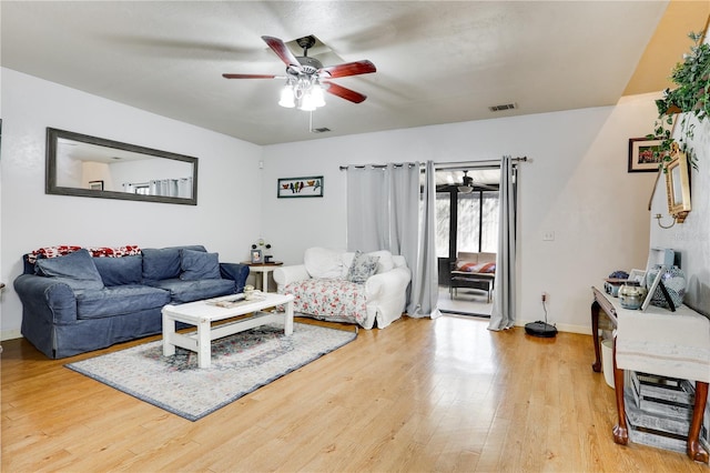 living room featuring baseboards, light wood-type flooring, visible vents, and a ceiling fan