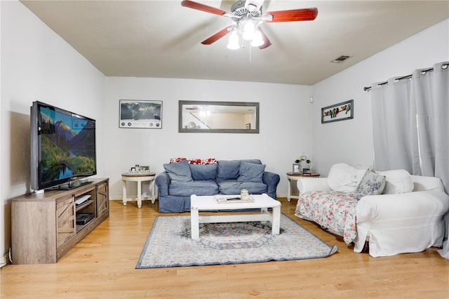 living room with light wood-style floors, visible vents, and a ceiling fan