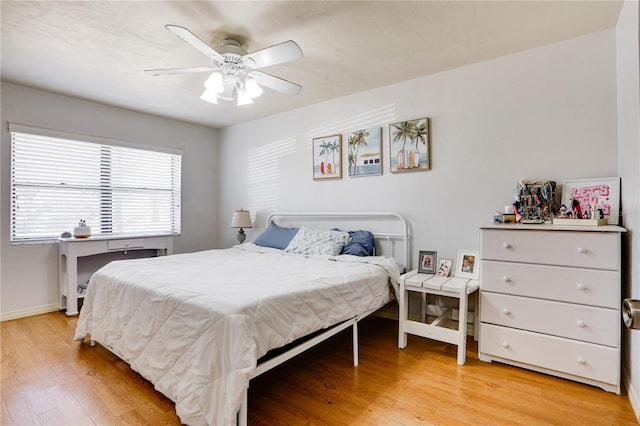 bedroom featuring light wood finished floors, baseboards, and a ceiling fan