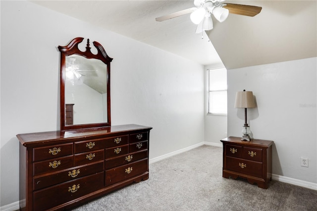 bedroom featuring light colored carpet, vaulted ceiling, baseboards, and ceiling fan