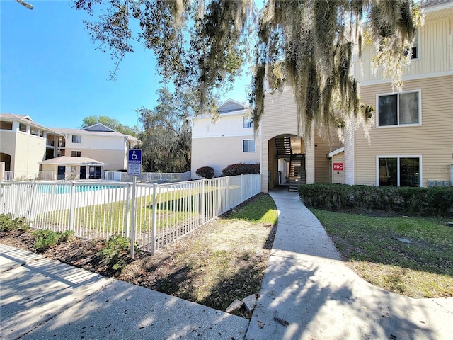 surrounding community featuring fence, a pool, and a lawn