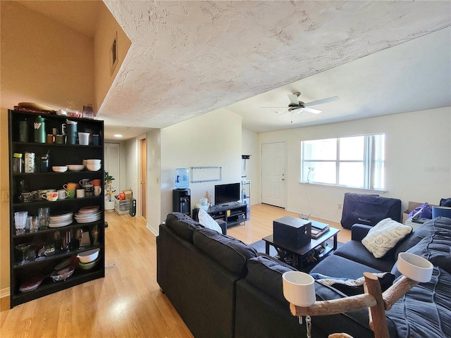 living area with visible vents, baseboards, light wood-type flooring, and ceiling fan