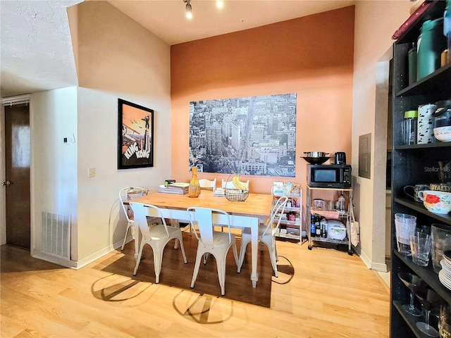 dining room with visible vents, baseboards, and wood finished floors