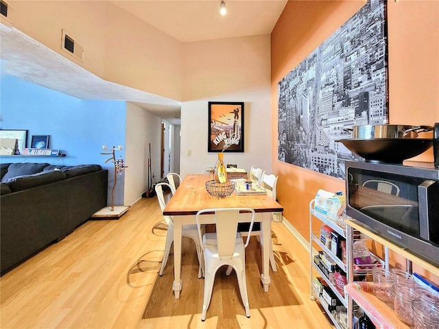 dining room with wood finished floors, visible vents, and baseboards