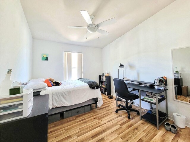 bedroom with vaulted ceiling, light wood-style flooring, and a ceiling fan