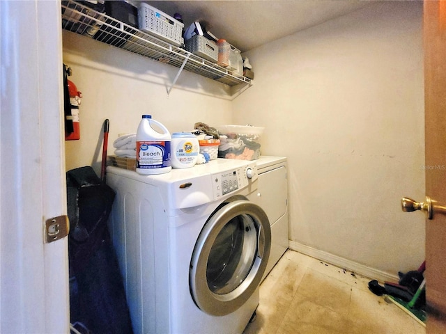 laundry area featuring washing machine and clothes dryer, laundry area, and baseboards