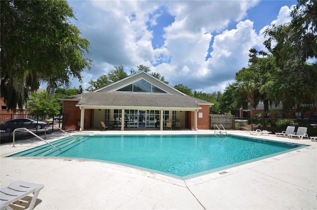 community pool with fence and a patio area