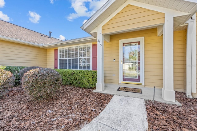 property entrance featuring a shingled roof