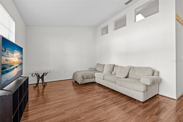 living area with baseboards and wood finished floors