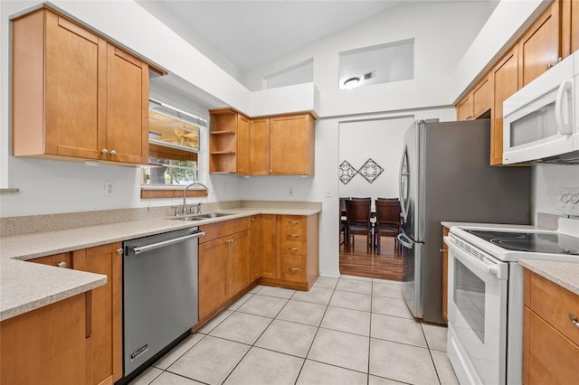 kitchen featuring lofted ceiling, light countertops, light tile patterned flooring, a sink, and white appliances