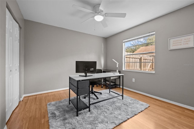 office space with a ceiling fan, baseboards, and wood finished floors