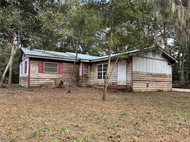 ranch-style house featuring metal roof and a front lawn