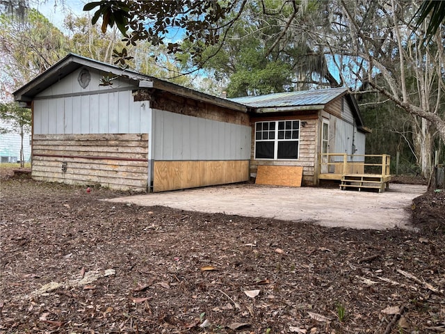 exterior space featuring a patio area, metal roof, and a wooden deck