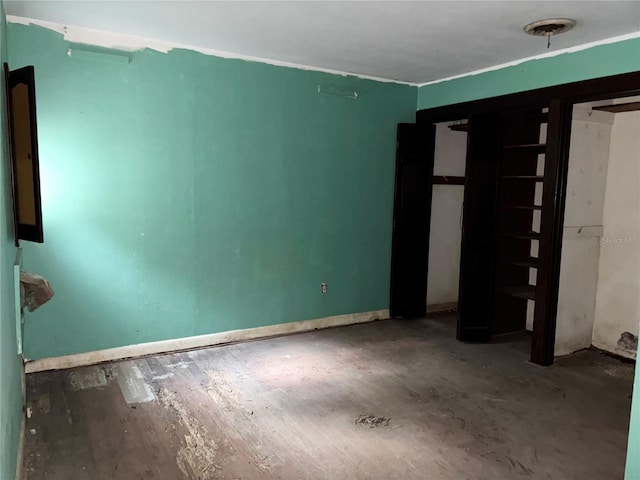 unfurnished bedroom featuring wood finished floors and baseboards