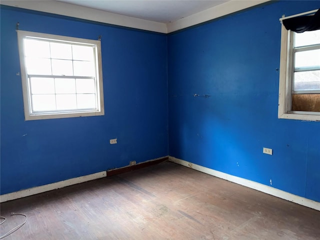 spare room featuring baseboards and dark wood finished floors