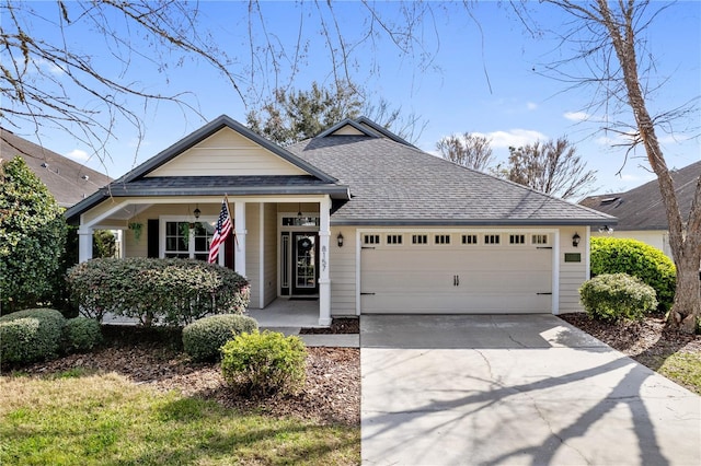 view of front of property with a garage, concrete driveway, a shingled roof, and covered porch