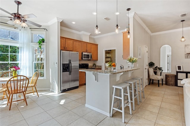 kitchen featuring stainless steel appliances, arched walkways, brown cabinets, and visible vents