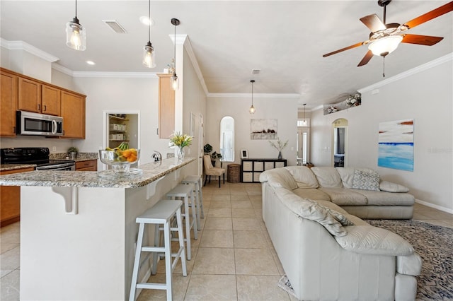 kitchen featuring arched walkways, visible vents, stainless steel microwave, and range with electric stovetop