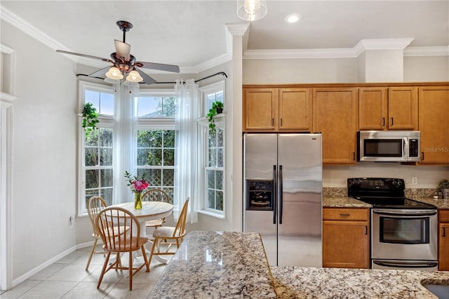 kitchen with stainless steel appliances, light stone counters, and brown cabinetry