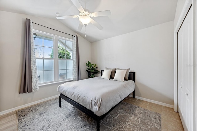 bedroom with ceiling fan, baseboards, vaulted ceiling, and a closet