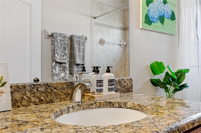 full bath with a tile shower and vanity