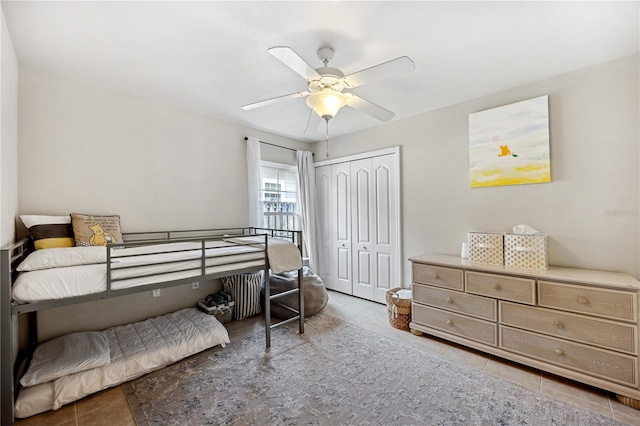 tiled bedroom featuring ceiling fan and a closet