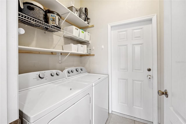 clothes washing area with light tile patterned floors, laundry area, and washer and clothes dryer