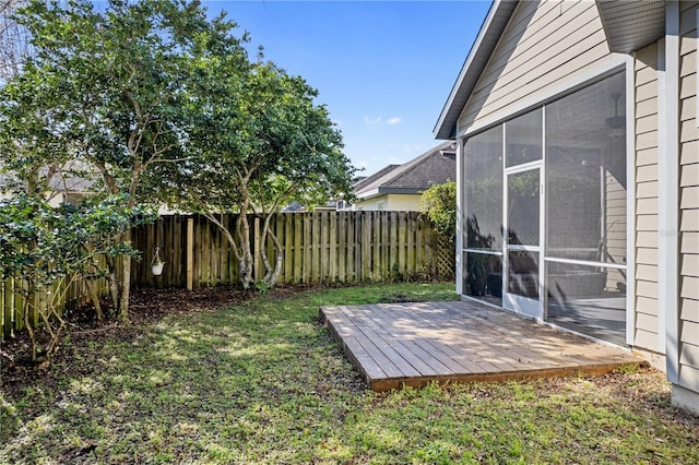 view of yard featuring a sunroom, fence, and a deck