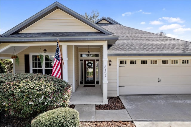 view of front of property with driveway, an attached garage, and roof with shingles