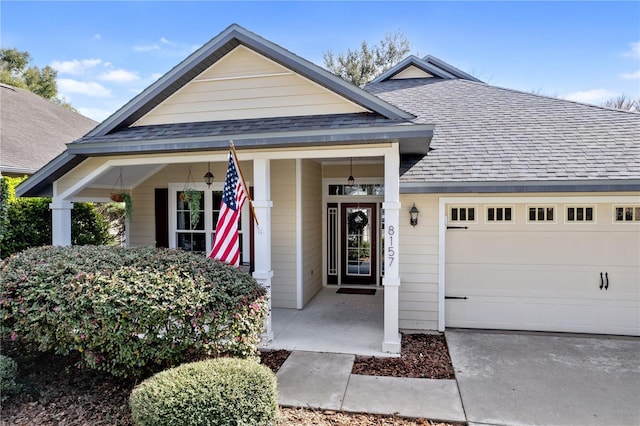 view of front facade featuring a garage, concrete driveway, a shingled roof, and a porch