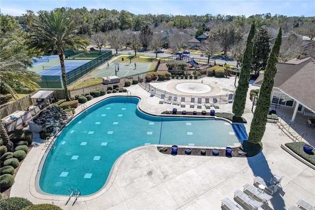 community pool with a patio area and fence