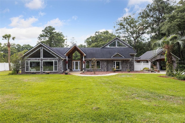 back of property with fence and a lawn