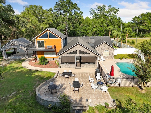 back of property with a fenced in pool, an outdoor fire pit, a patio area, stone siding, and a fenced backyard