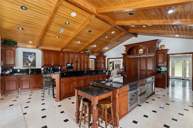 kitchen with a large island, a kitchen bar, a sink, and beam ceiling