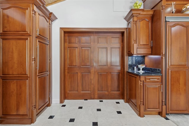 kitchen featuring dark stone counters and brown cabinets