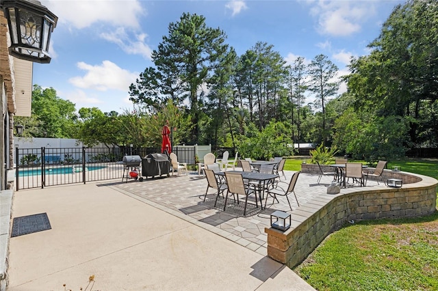 view of patio featuring outdoor dining space, fence, and a fenced in pool