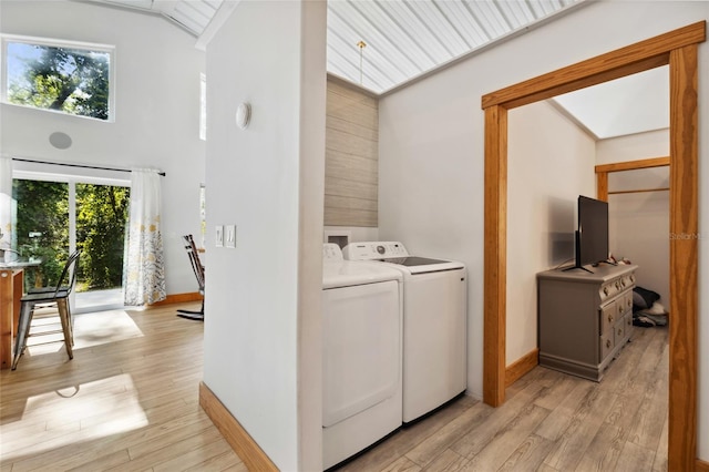 laundry area featuring laundry area, light wood-style flooring, baseboards, and washer and dryer