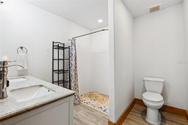 full bathroom with double vanity, visible vents, toilet, a shower stall, and wood finished floors