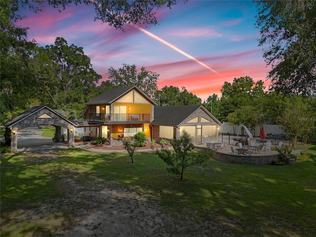 view of front of house featuring a front yard, a patio, and a balcony